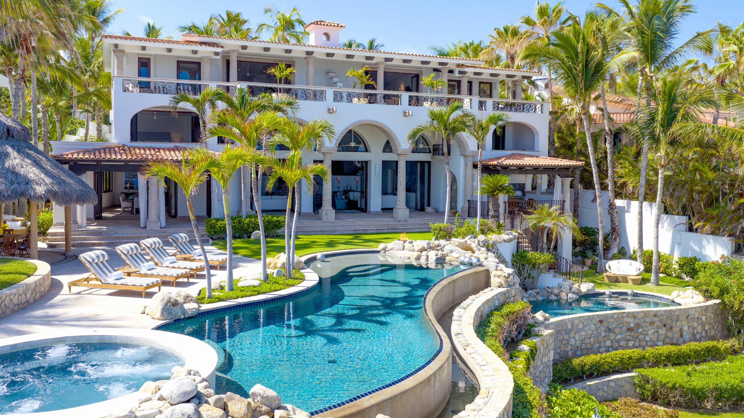 Palmilla La Caleta A once-in-a-generation legacy estate, never before on the market, this iconic beachfront residence offers incomparable prestige on the sands of Palmilla Bay, one of Cabo's most coveted and swimmable beaches. Set on a rare half-acre parcel directly on the water, the home features six bedrooms, six and a half baths, plus a full attached apartment, all executed in classic Palmilla style with timeless elegance and modern comfort. From the moment you enter, the architecture reveals its intention: a grand foyer flows effortlessly into an open living area and bar, framed by soaring ceilings and vast windows that disappear into the Baja breeze. The interiors dissolve into the outdoors, unveiling a dramatic terrace that cascades to a manicured lawn, infinity-edged pool, waterslide, spa, and expansive entertaining pavilion designed for unforgettable gatherings beneath the stars.The second level hosts two principal suites, each opening to a vast private terrace with sweeping for sale